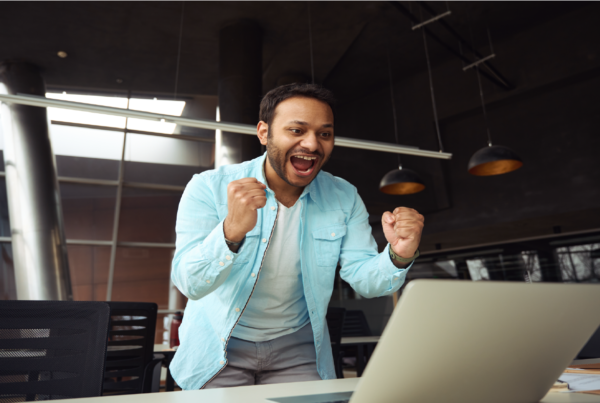 excited young man looking at laptop